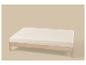 Lit simple en bois clair avec matelas crème sur fond beige.