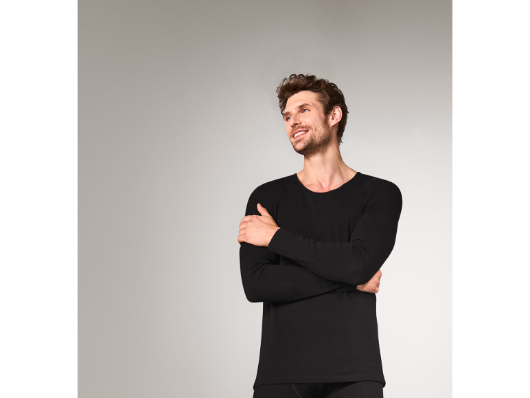 Homme souriant portant un sous-vêtement thermique noir à manches longues.