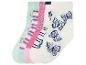 Quatre paires de chaussettes pour enfants avec des motifs variés : fleurs, rayures et papillons.