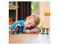 Un enfant joue avec un set LEGO Minecraft avec un portail du Nether et des figurines.