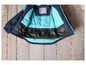Une veste bleue et turquoise avec une étiquette de nom à l'intérieur.