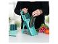 Femme utilisant un Nicer Dicer pour trancher un concombre, avec des légumes en arrière-plan.