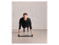 Homme faisant des pompes sur une planche d'entraînement.