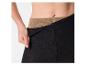 Femme portant des leggings noirs avec une ceinture beige visible.