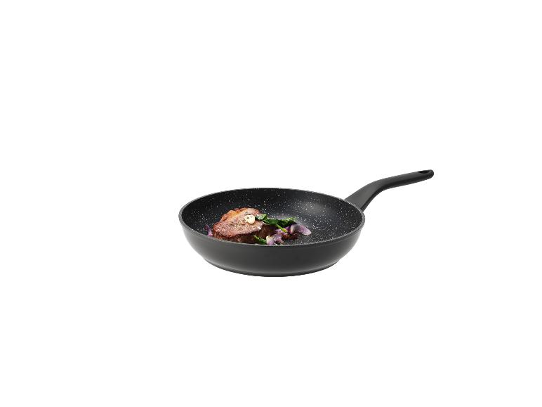 Poêle noire avec un steak, des épinards et de l'oignon rouge