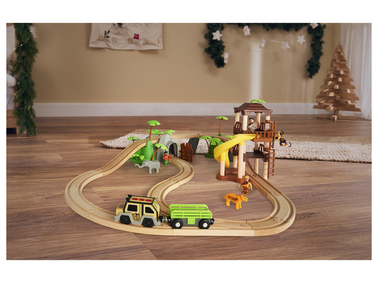 Une voie ferrée en bois avec une jeep, un zoo et des figurines.