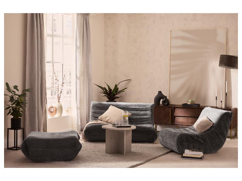Salon avec un canapé modulaire gris, un pouf assorti et un fauteuil de relaxation.