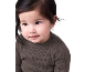 Un adorable bébé aux cheveux foncés portant un pull côtelé.