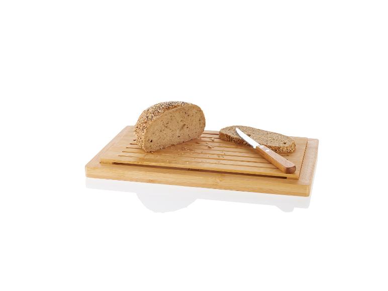 Pain aux graines, planche à découper en bambou et couteau.