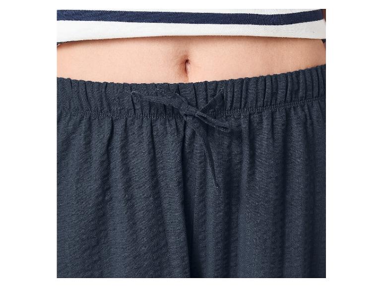 Ventre d'une personne portant un haut rayé et un pantalon de pyjama bleu marine avec cordon de serrage.