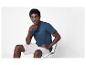 Un homme avec un t-shirt bleu et un short blanc.