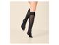 Jambes de femme en chaussettes montantes noires avec une semelle renforcée.