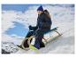 Enfant en veste de ski bleue CRIVIT glissant sur une luge sur une colline enneigée.
