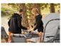 Couple prépare le petit-déjeuner au camping avec une table pliante et des chaises.