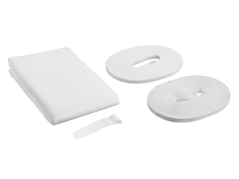 Une toile de maille blanche, deux rouleaux de velcro et un outil en plastique blanc.