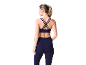 Femme de dos portant un soutien-gorge de sport bleu foncé et un legging assorti.