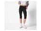 Modèle portant un legging noir 3/4 et des baskets blanches.