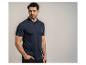 Homme en polo bleu marine et pantalon noir, posant la main dans la poche.