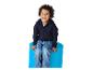 Enfant joyeux en sweat à capuche bleu marine et jean, assis sur un tabouret bleu.