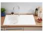 Évier de cuisine blanc avec robinet, plan de travail en bois et carrelage blanc.