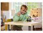 Un garçon construit un véhicule Lego Sonic the Hedgehog sur une table en bois.