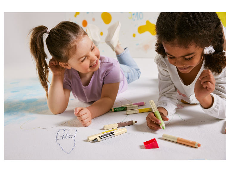 Enfants dessinant avec des crayons de cire pastel.