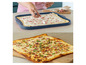 Une tarte flambée avec du lard, des oignons et de la crème, prête à servir.
