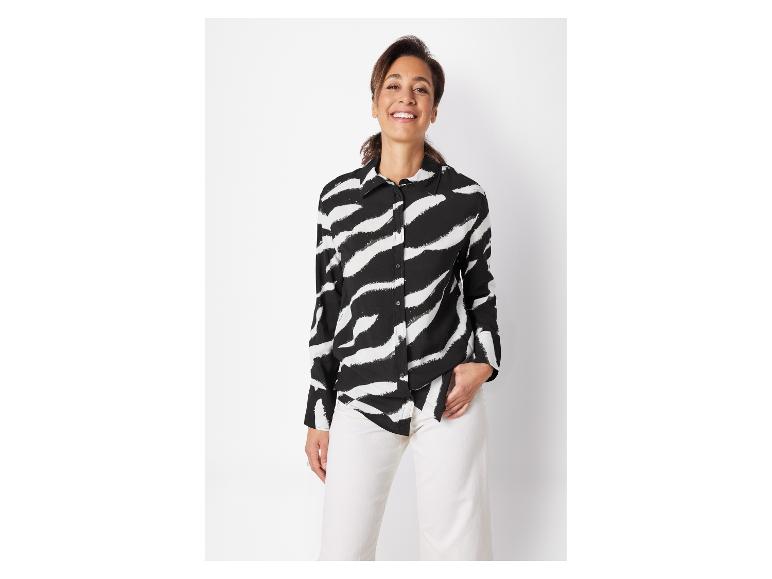 Chemise à rayures zébrées noire et blanche et pantalon blanc.