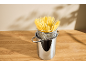 Spaghetti dans une casserole en acier inoxydable avec passoire sur une table en bois.