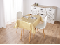 Table à manger avec nappe dorée, deux chaises et un buffet blanc.