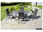 Une table de jardin en verre avec quatre chaises pliantes sur une terrasse en bois.