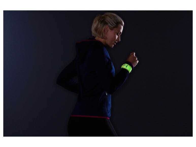Une femme en tenue de sport portant un bracelet réfléchissant Chimpri au bras.