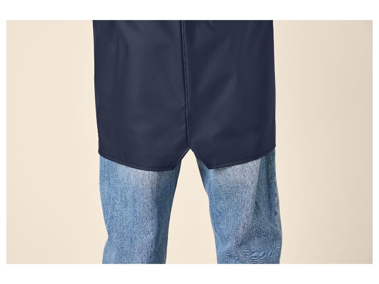 Partie inférieure d'une veste de pluie bleu foncé sur un jean bleu.