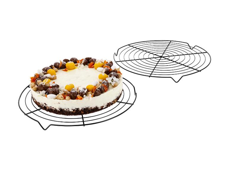 Cheesecake avec chocolat, noix et décorations de fruits sur une grille de refroidissement.