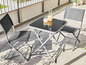 Deux chaises pliantes et une table en verre sur une terrasse.
