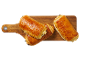 Pains au chocolat dorés sur une planche à découper en bois.