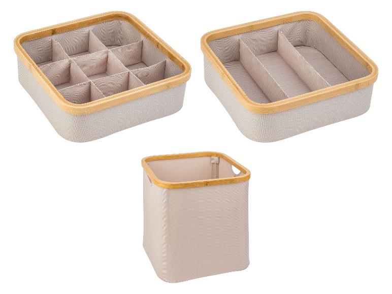 Boîtes de rangement en tissu beige avec cadre en bambou : une avec compartiments, une autre plus grande et une corbeille.