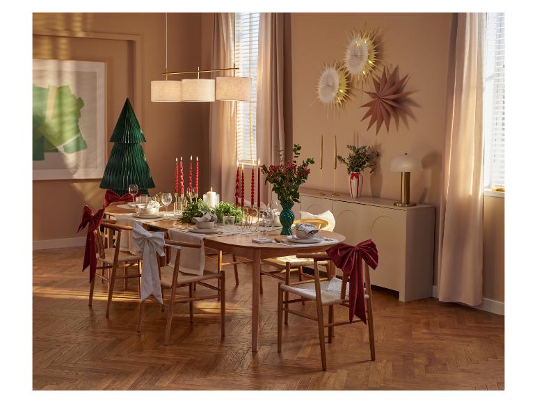 Table de Noël élégamment dressée avec des chaises en bois et des décorations festives.