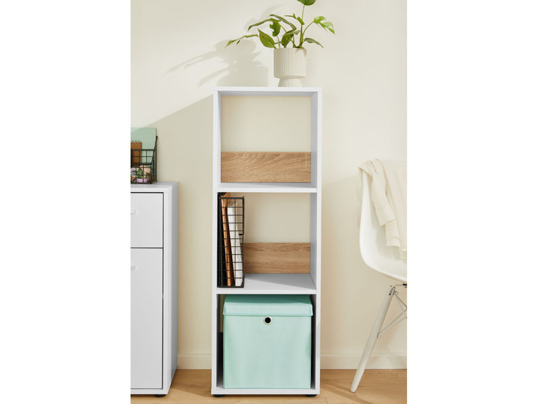 Une étagère blanche avec trois étagères et une boîte de rangement.