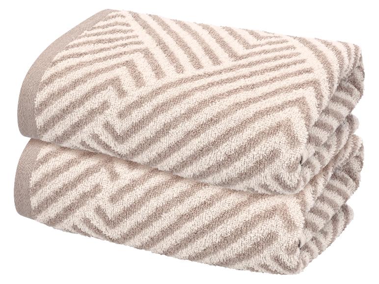 Deux serviettes pliées avec un motif zigzag marron clair et blanc