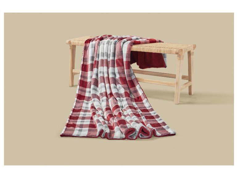 Couverture à carreaux rouges et blancs drapée sur un banc en bois.