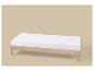 Lit de jour en bois clair avec matelas blanc sur fond beige