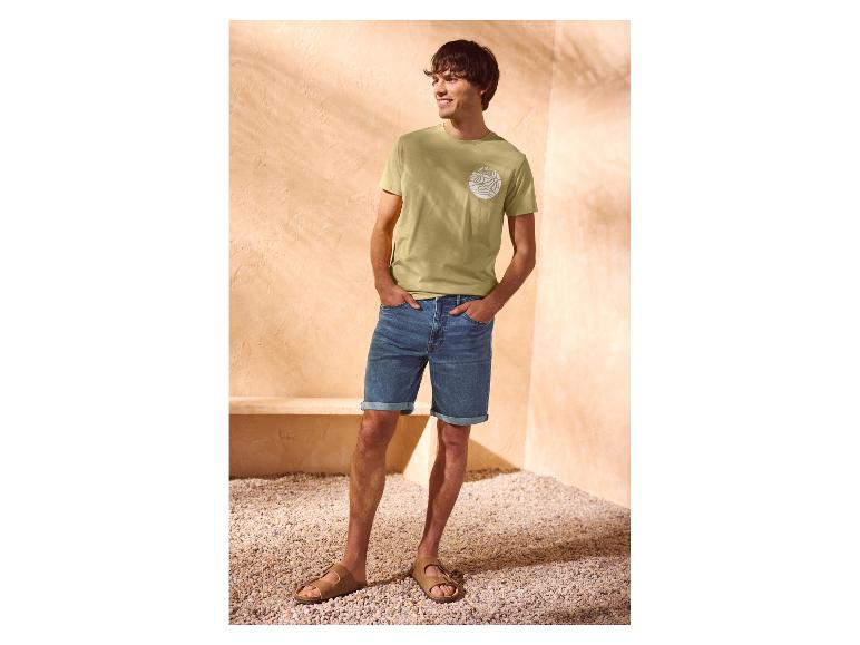 Homme en t-shirt vert 'summer wave' et short en jean.