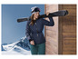 Une femme portant une veste de ski bleue et un ski sur l'épaule