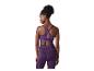 Femme en brassière de sport violette avec dos croisé et leggings assortis, vue de dos.