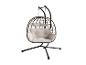 Fauteuil suspendu œuf en rotin marron avec coussins blancs et support en métal noir.