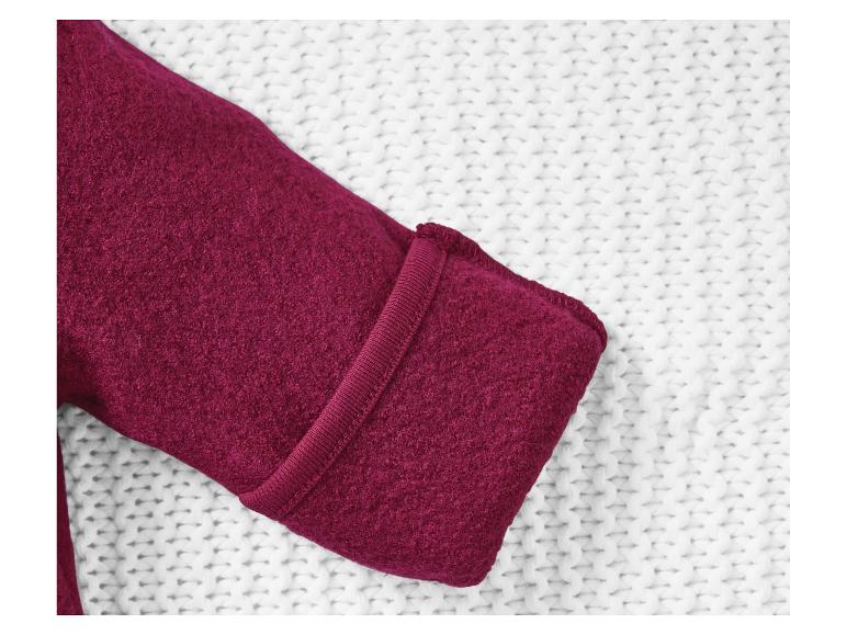 Pull rouge foncé sur un tissu en tricot blanc.
