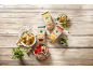 Produits céréaliers biologiques et salades sur une table en bois.
