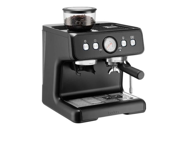Machine à café noire avec moulin intégré et manomètre, avec des grains de café dans le récipient.