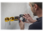 Un électricien installe des prises murales.